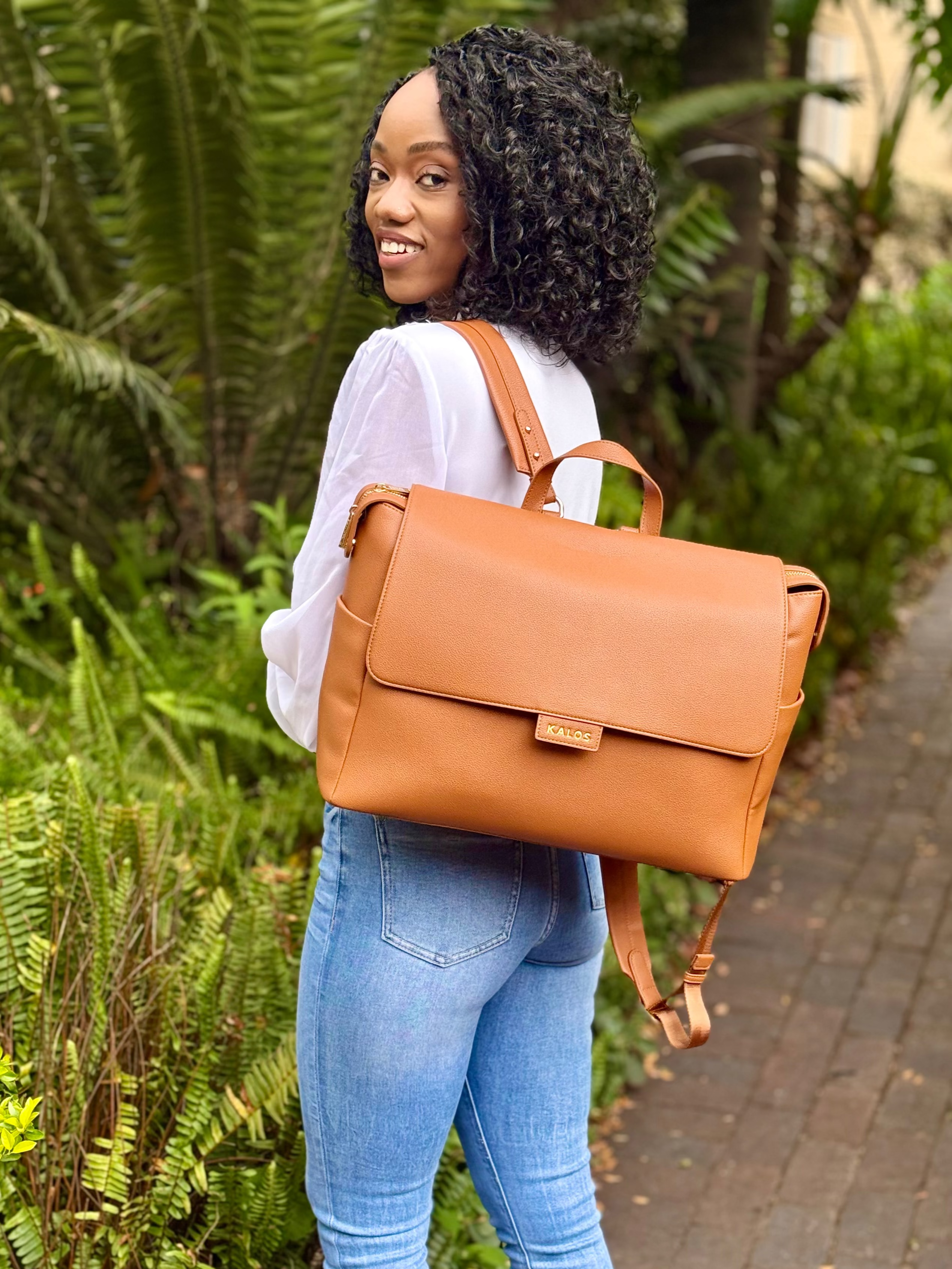 Rosey brown leather diaper backpack outdoors.